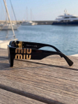 Miu Miu SMU09W P&auml;ikeseprillid - Must Kassikujulised Raamid Kuldse Logoga must