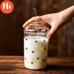 Kuumuskindel klaasist kontoriteekass Loominguline l&auml;bipaistev kaanega kohvikruus ja &otilde;lgedest majapidamispiima-mahla tass reisijoogid