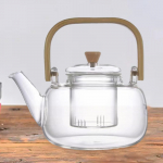 Klaasist teekann l&auml;bipaistvad pliidid Keedetud tee k&auml;sitsi puhumine eemaldatava infusiooniga